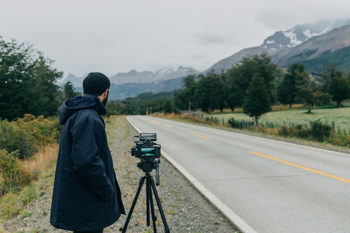 Cámara en trípode filmando una ruta con montañas