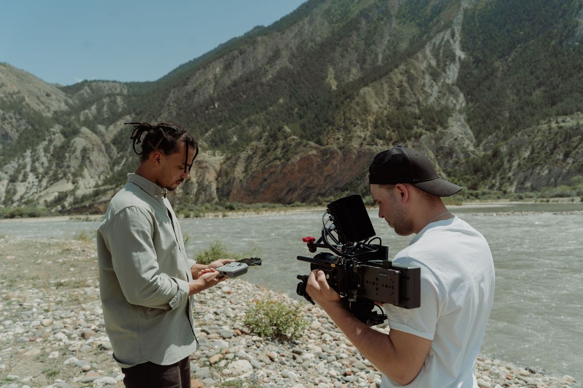 Equipo de filmación grabando junto a un río de montaña